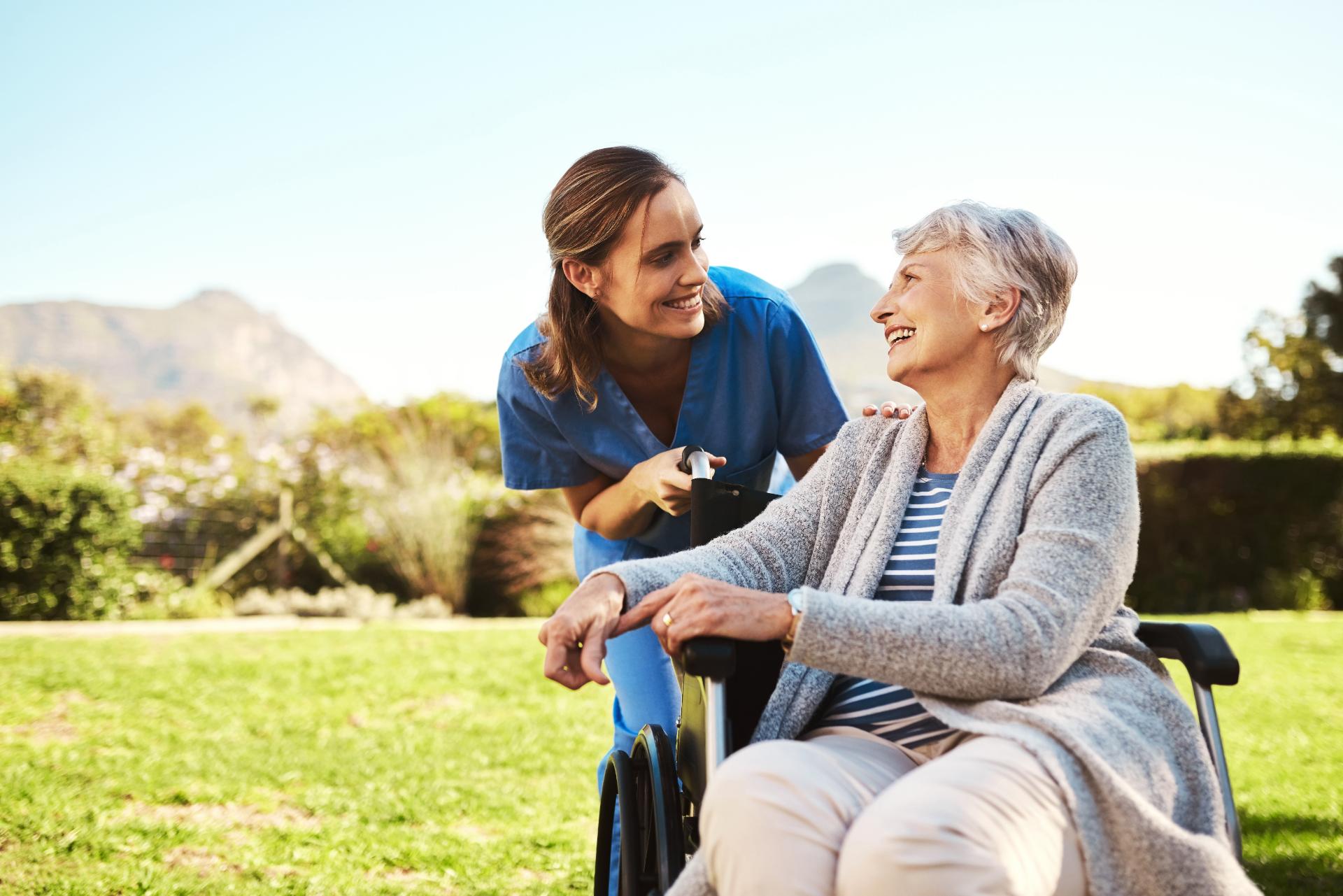 Patient taking care of elderly woman outdoors