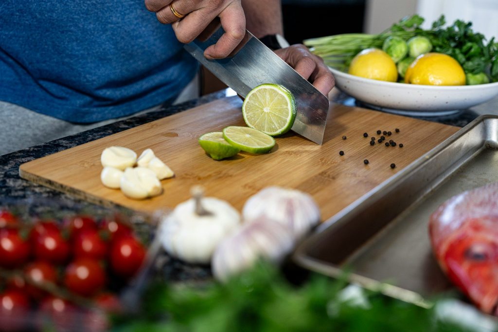 a person cutting a lime on a cutting board